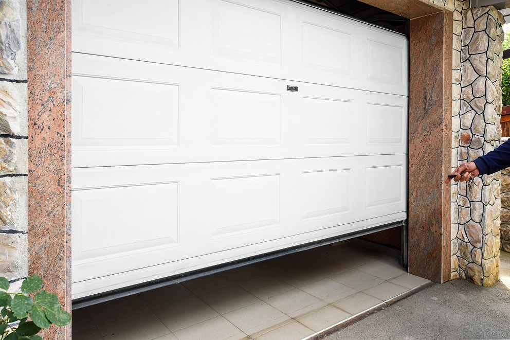 Białą bramę garażową trzeba regularnie malować, aby wyglądała nienagannie. Pomoże Supermal Emalia Olejno-Ftalowa do drewna i metalu ŚNIEŻKA