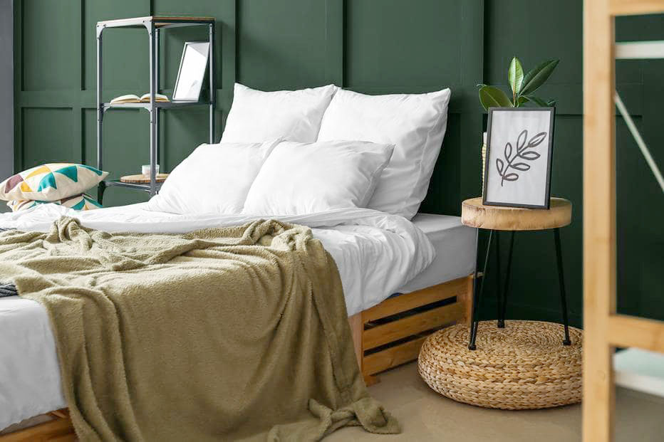 Zielona ściana za łóżkiem w sypialni
